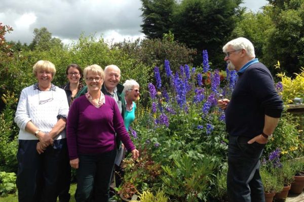 Victor Henry greeting the visitors as all admire the wonderful delphiniums.